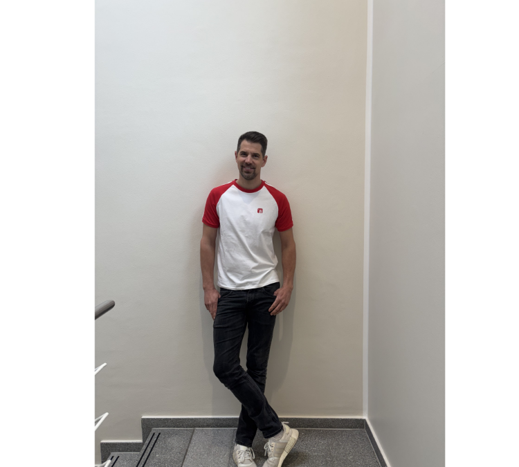 Männliches Model mit T-Shirt in weiß mit roten mit weißen Strichen Ärmeln, rotes Finanz Informatik Logo auf der linken Brust